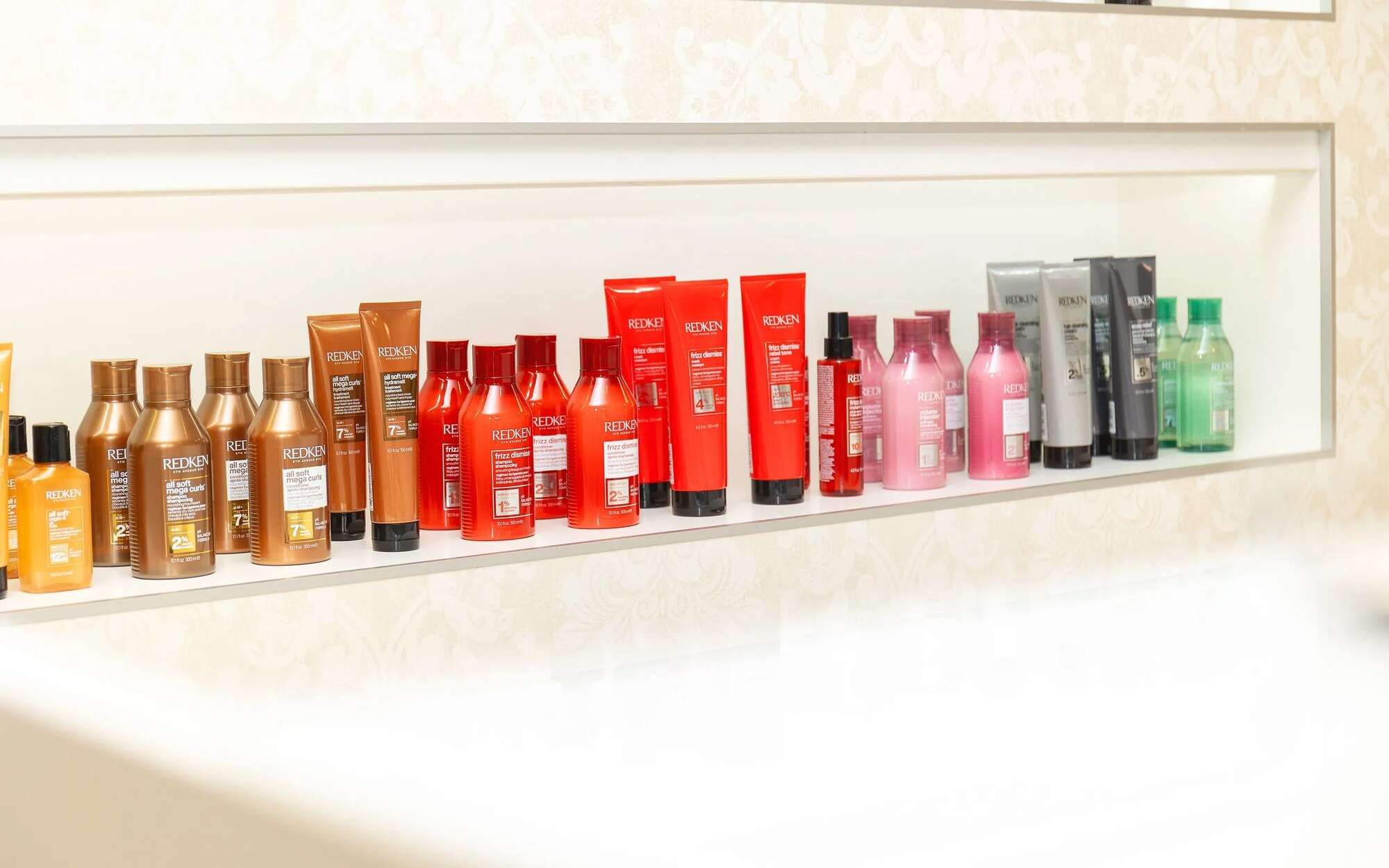 Produktregal mit Redken-Shampoos und -Pflege im Salon