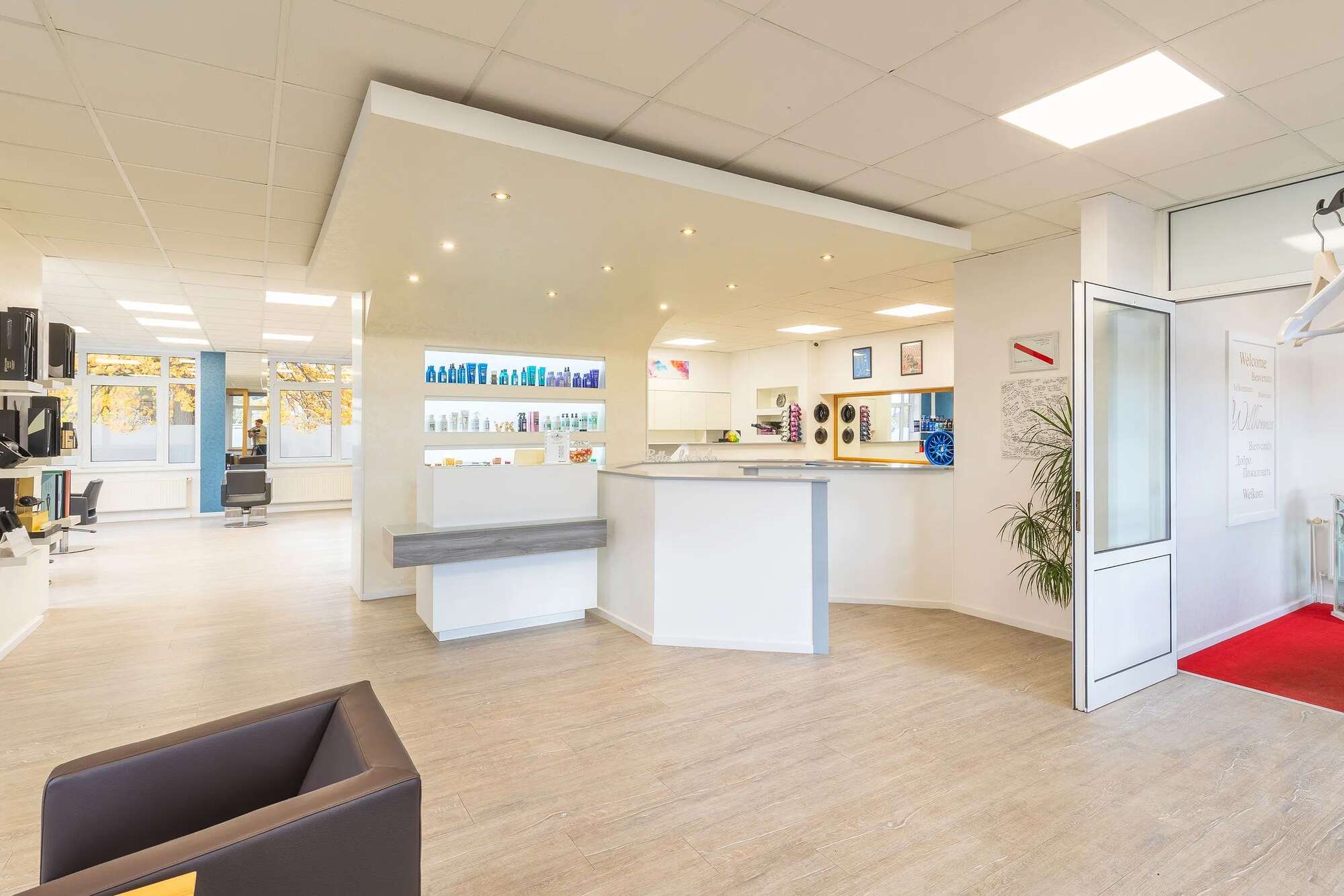 Empfangstresen des Salons mit Produktregal und Eingangstür
