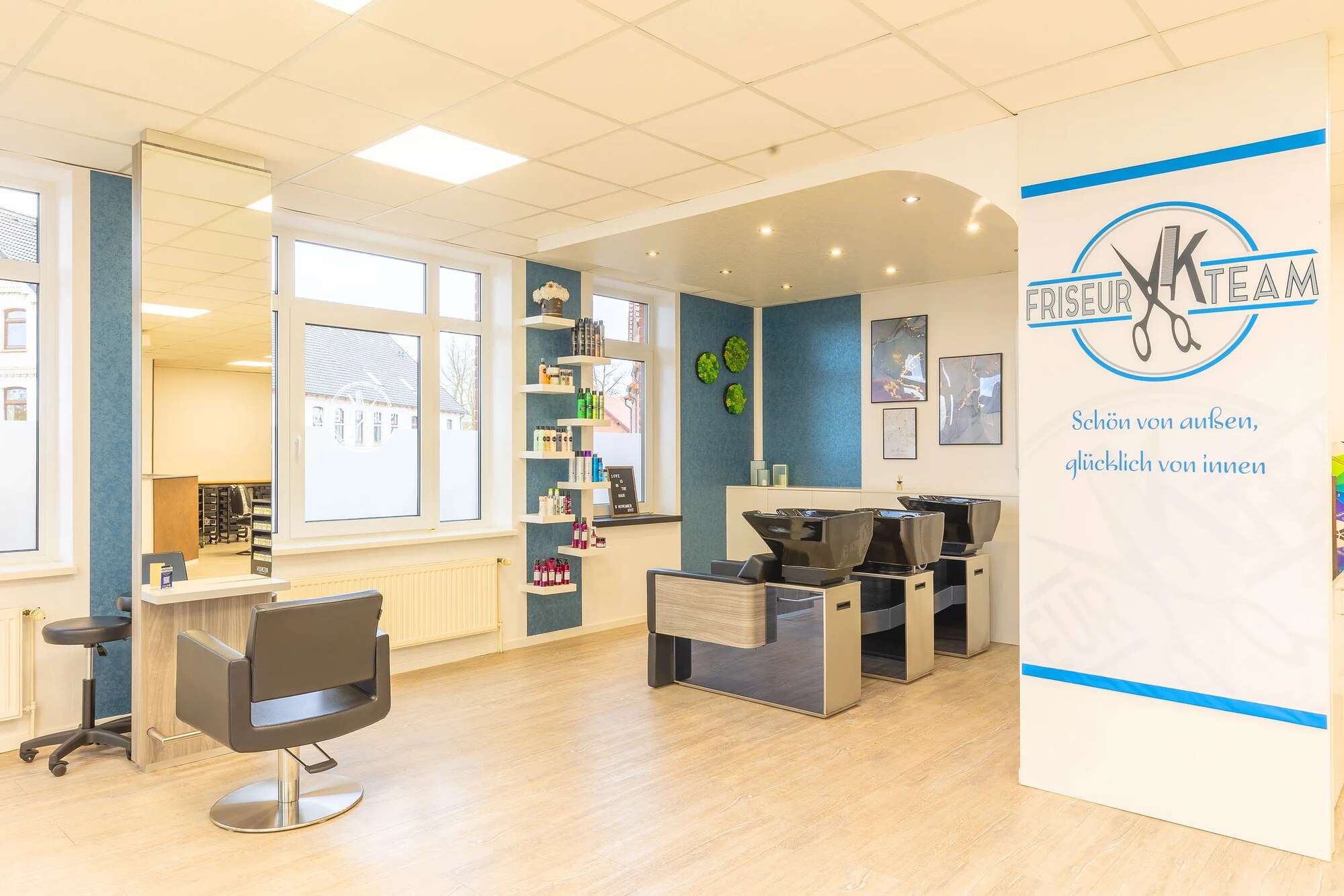 Waschplätze im Salon, daneben ein Aufsteller mit dem Spruch: Schön von außen, glücklich von innen
