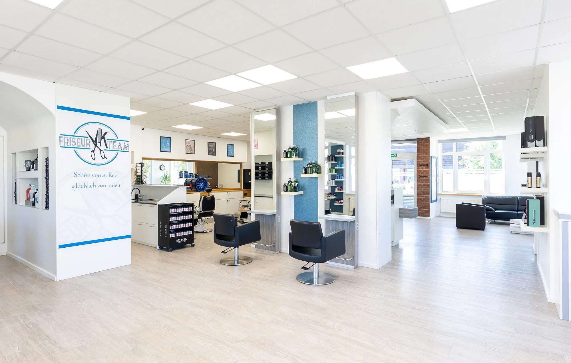 Blick durch den Salon mit Bedienplätzen und dem Aufsteller mit dem Salon-Logo